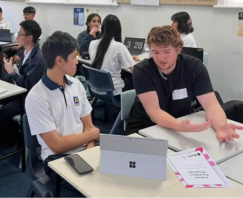 Alfie Curran-Ragan mentoring students in a classroom through UWA's Bloom program at Perth Modern.