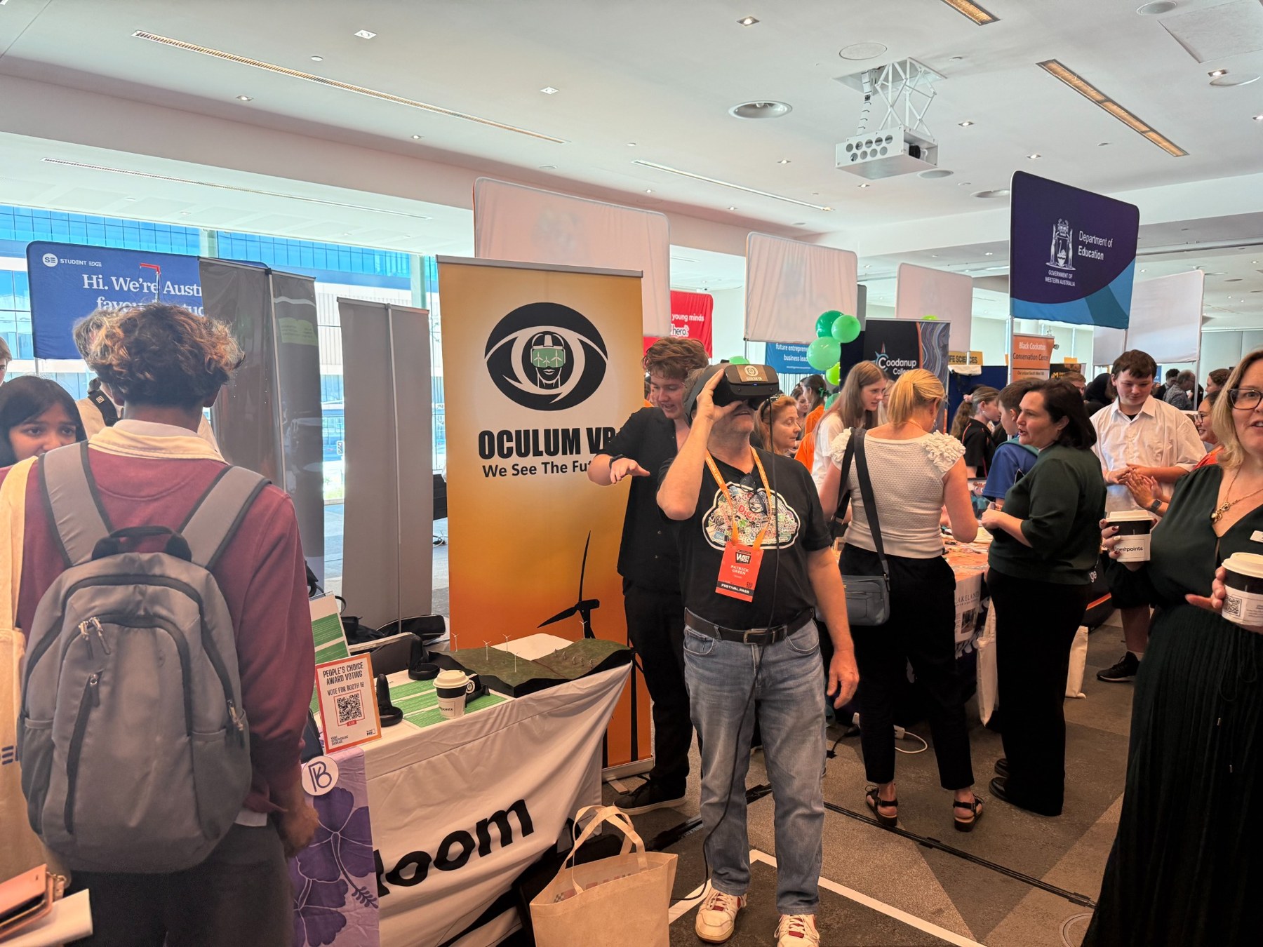 Oculum VR exhibition stand with a visitor trying a VR headset at an event.